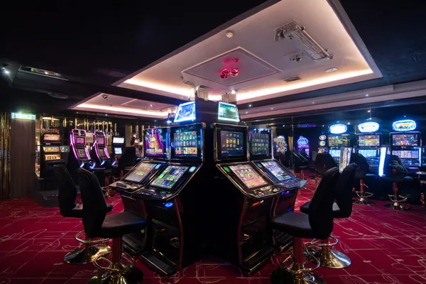A woman in a luxurious green gown next to an ornate roulette wheel, capturing the upscale casino mood of 21GAME.